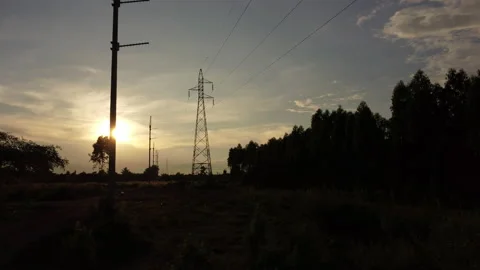Aerial view of high voltage pylons and wires in the sky at sunset in countryside Vídeos de archivo 218413616