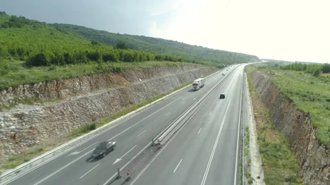 Aerial view of highway between green hills with busy summer traffic in hot day Stock Footage 156792471