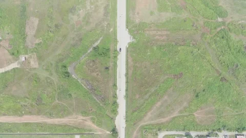 Aerial view of highway between trees and green open space Stock Footage 235546577