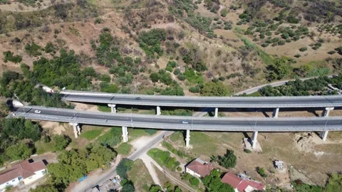 Aerial view of highway bridge pillars over rural mountain valley Stock Footage 343961452