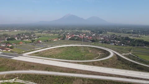 Aerial view of a highway interchange loop with Mount Merapi, Indonesia. Stock Footage 333346706