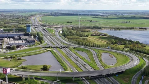 Aerial view of highway interchange traffic flowing through green landscape Видео 336617128