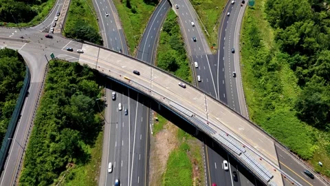 Aerial view of highway interchange traffic moving through green... Stockbeeldmateriaal 340657892