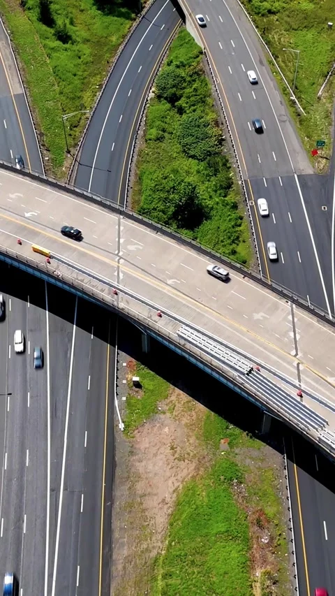 Aerial view of highway interchange traffic moving through green... Stock Footage 344332548