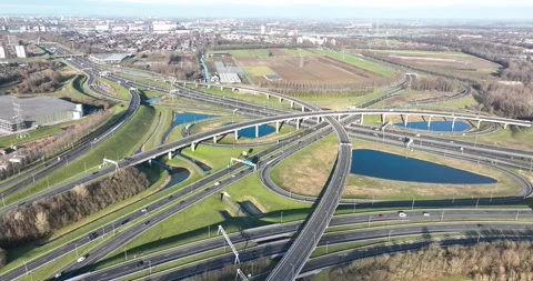 Aerial view of a highway intersection with a clover-leaf interchange in The Stock Footage 240942644
