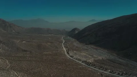 Aerial view of highway road in between the mountains Stock Footage 219860013