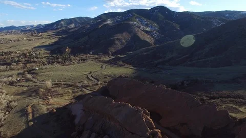 Aerial view of highway by rock cliffs against mountains on sunny day, drone Stock Footage 128846592