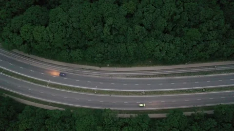 Aerial view of a highway through a forest at dusk Stock Footage 338013626