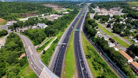 Aerial view of highway traffic moving through suburban hills with roads... Video stock 340657900