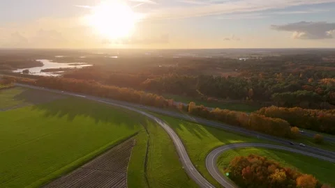 Aerial view of highway traffic at sunset through rural landscape Stock-Footage 323384341