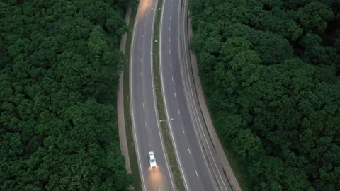 Aerial view of highway traffic through forest at dusk Stock Footage 338013638