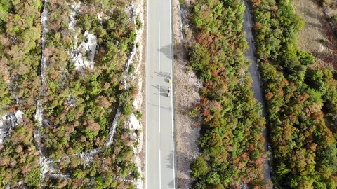 Aerial View Of A Highway With Two Cyclists Riding Along Stock Footage 128783056