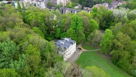Aerial view of a historic building surrounded by lush green trees, Belgium Stock Footage 334819435