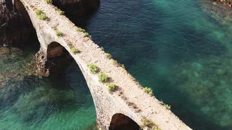 Aerial View of Historic Stone Bridge Over Turquoise Coastal Waters Stock Footage 320202560