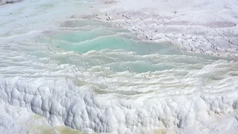 Aerial view of hot springs with blue water white baths. Travertines of Pamukkale Stock Footage 220881653