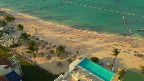 Aerial view of a hotel with a rooftop pool on the beach in Punta Cana Stock Footage 306402926