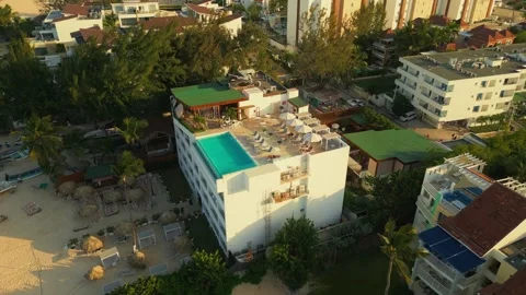 Aerial view of a hotel with a rooftop pool on the beach in Punta Cana Stock Footage 306402983
