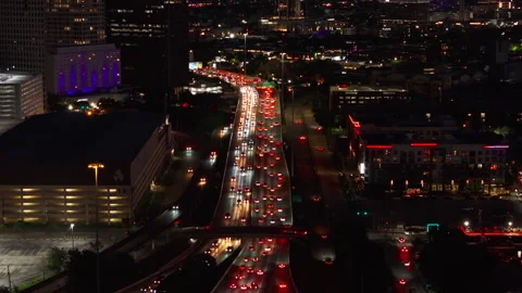 Aerial view of Houston's freeway at night, with bright city lights and heavy Stock Footage 276237572