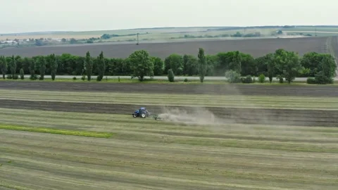 Aerial view hovering over the tractor plows the land in the village. The proc Stock Footage 137262490