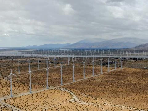 Aerial view of huge array of gigantic wind turbines spreading over the desert in Stock-Fotos