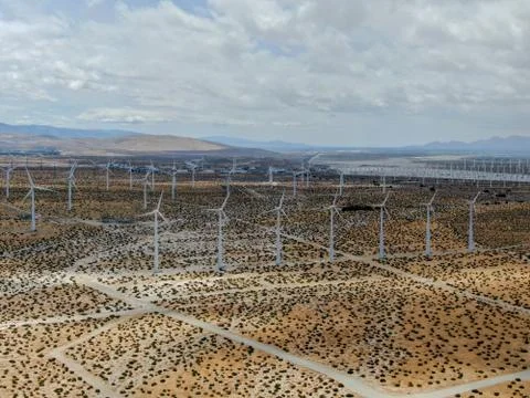 Aerial view of huge array of gigantic wind turbines spreading over the desert in Stock-Fotos