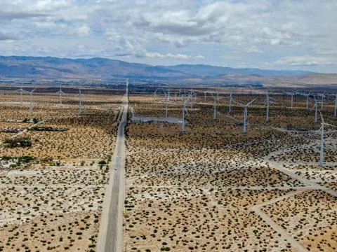 Aerial view of huge array of gigantic wind turbines spreading over the desert in Stock Photos