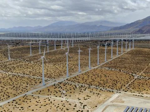 Aerial view of huge array of gigantic wind turbines spreading over the desert in Foto stock