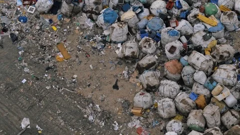 Aerial view of huge city garbage dump at sunset. Birds fly over piles of trash Stock Footage 92861306