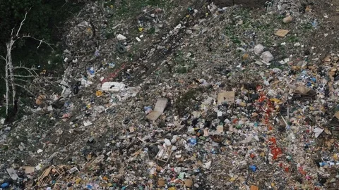 Aerial view of huge city garbage dump at sunset. Birds fly over piles of trash Stock Footage 92862959
