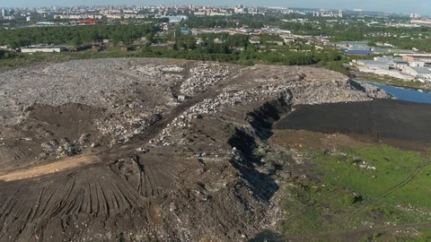 Aerial view of huge city garbage dump at sunset. Birds fly over piles of trash Stock Footage 92866090