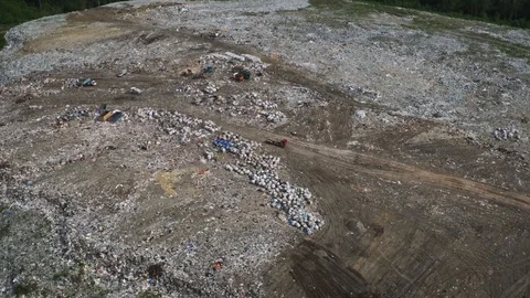 Aerial view of huge city garbage dump at sunset. Garbage truck unloads trash Stock Footage 92885960