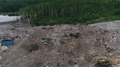 Aerial view of huge city garbage dump at sunset. Garbage truck unloads trash Stock Footage 92889682