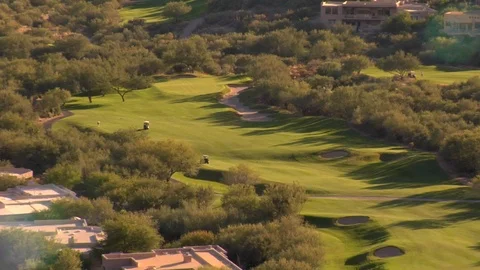 Aerial view of huge golf course with golf carts and mountains Stock Footage 125275853