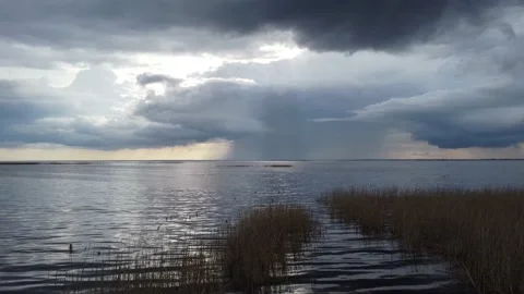 Aerial view of a huge lake with dramatic thunder clouds and light water ripples Stock Footage 154825586