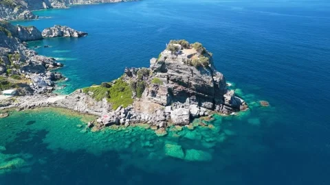 Aerial view of the iconic Agios Ioannis Church perched atop a dramatic rocky Stock Footage 346706812