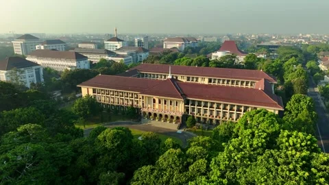 Aerial view of iconic UGM campus building surrounded by greenery Stock Footage 346739877
