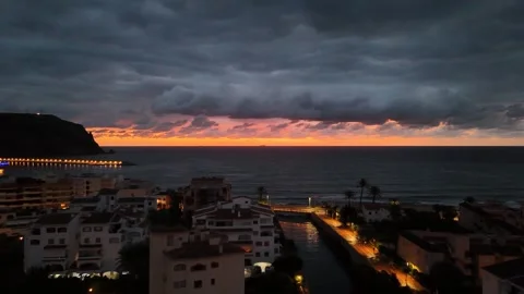 Aerial view of illuminated seafront at dramatic sunset, Javea, Spain Stock Footage 339989898