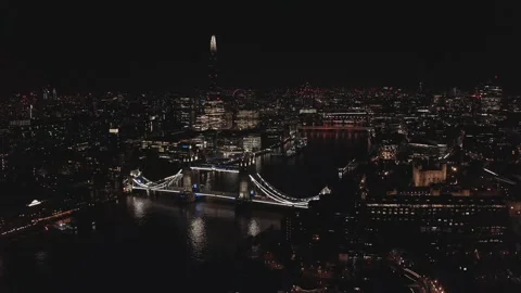 Aerial view to the illuminated Tower Bridge and skyline of London at night, UK. Stock Footage