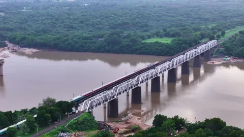 Aerial View of an Indian Train Crossing a River Bridge Видео 341548111