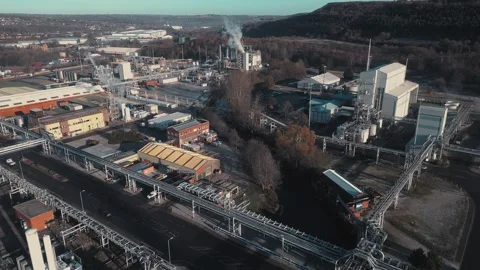 Aerial view of industrial complex beside river. Blue tanks and pipes dominate Stock Footage 345668596