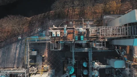 Aerial view of industrial complex beside river. Blue tanks and pipes dominate Stock Footage 345668845