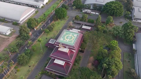 Aerial View of Industrial Complex with Rooftop Helipad and Green Landscaping Stock Footage 343768688