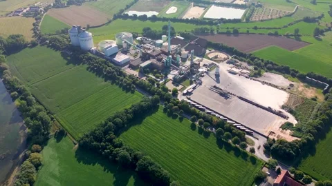 Aerial view of an industrial complex surrounded by green fields and farmland Stock Footage 315520389