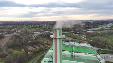Aerial view of industrial emissions stack with colorful stripes, surrounded by Stock Footage 341468098