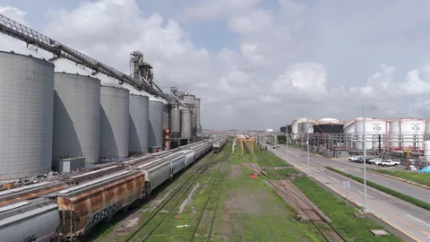 Aerial view of industrial infrastructure featuring a freight train and silos at Vídeos de archivo 345102728