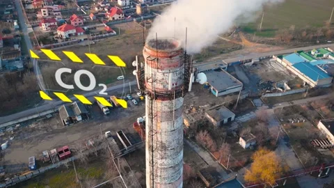 Aerial view of an industrial pipe polluting the air next to living people. 4K. Stock Footage 87560512
