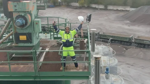 Aerial view of industrial worker jumping with excitement outdoors on top of Stock Footage 124304524