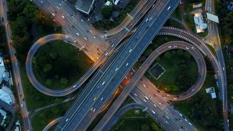 Aerial view of infinity highway road interchange with car speeding at dusk Stock-Footage 90806924