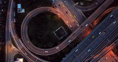 Aerial view of infinity highway road interchange with car speeding at night Stock-Footage 90807812