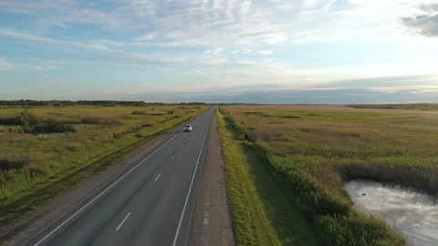 Aerial view of an intercity road between green fields in marshland. Beautiful Stock Footage 209139992